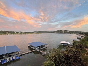 A waterfront property with a dock, a covered boat house, and a small building. - Fun N Sun Lake Travis Waterfront Condo 104 Boat Slip Available (Spicewood)