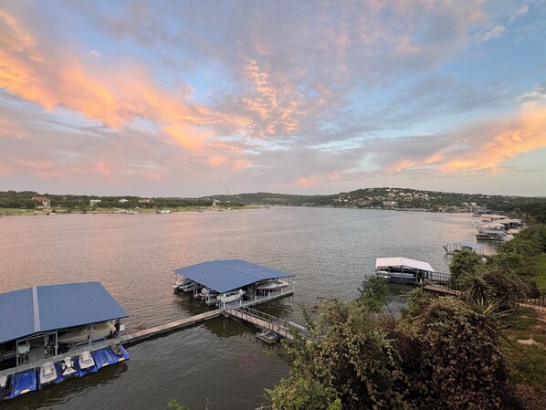 A waterfront property with a dock, a covered boat house, and a small building. - Fun N Sun Lake Travis Waterfront Condo 104 Boat Slip Available (Spicewood)