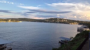 Une vue sur le front de mer, avec un quai, un bateau et une colline parsemée de bâtiments.