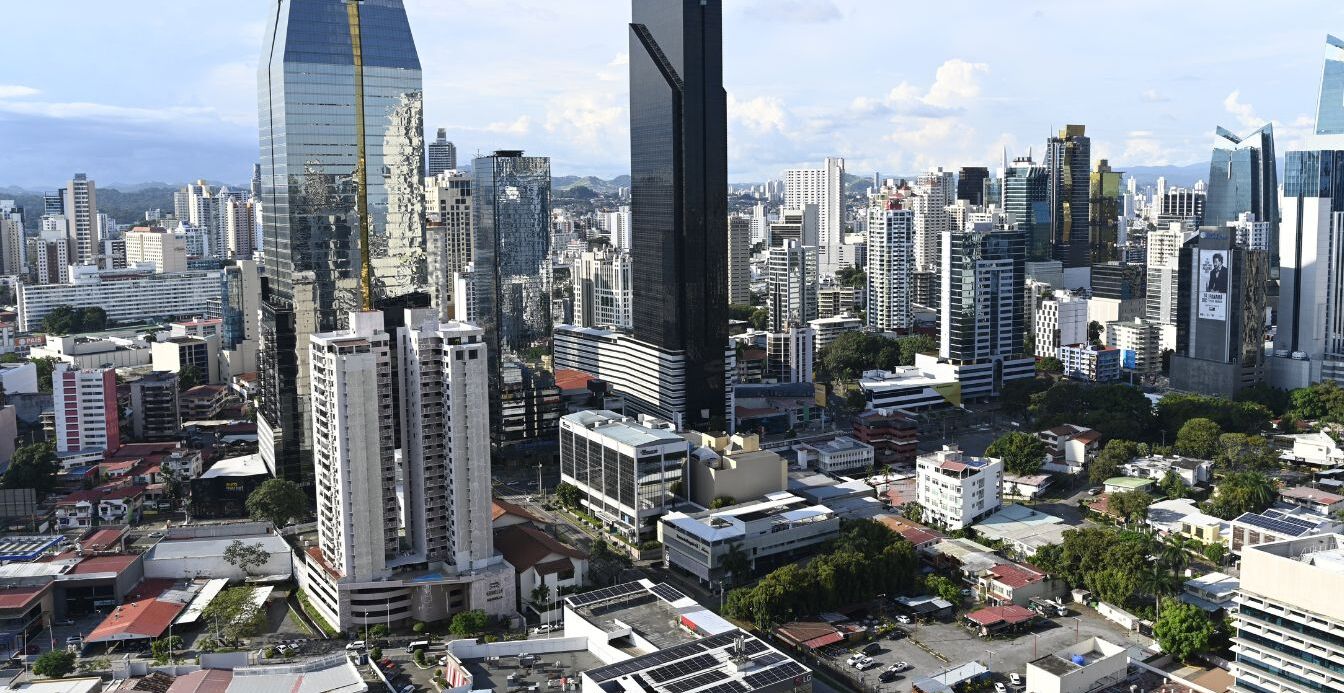 Un paisaje urbano con modernos rascacielos, incluyendo un imponente edificio de gran altura con un diseño singular.