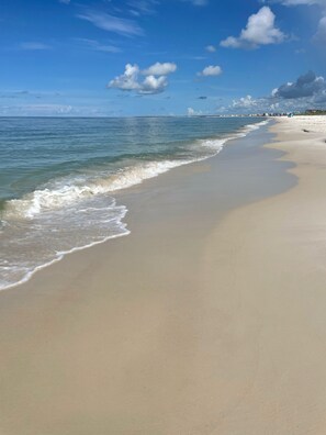 A beach with a wide sandy shore and gentle waves.