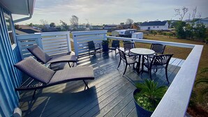 Eine Holzterrasse mit Gartenmöbeln, darunter ein Tisch und Stühle, sowie einem Blumentopf.