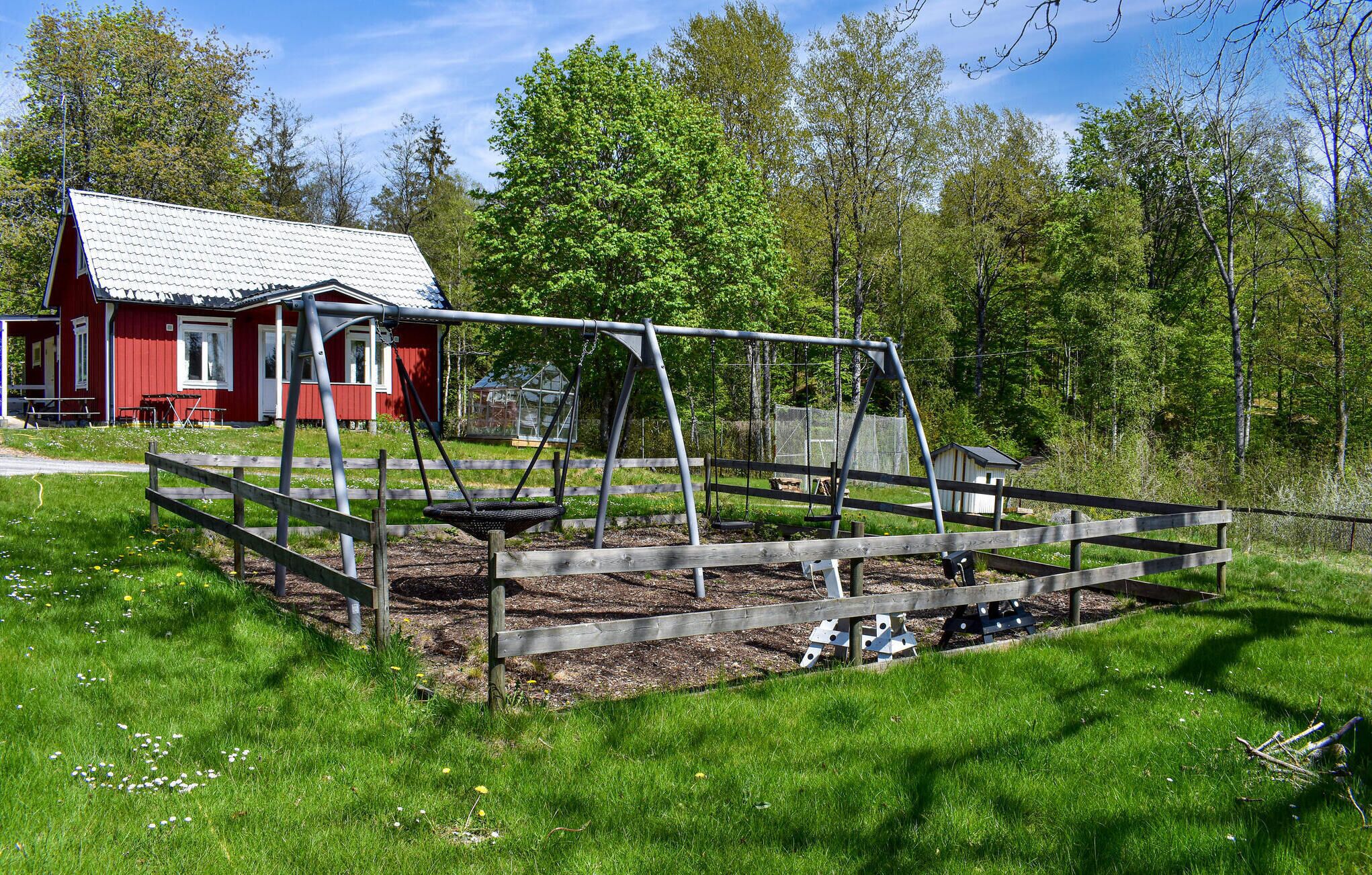 A red wooden house with a metal frame structure in front.