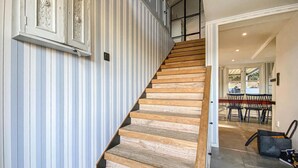A staircase with wooden steps and a striped wall. - 3 bedroom beautiful home in Hovås (Hovås)