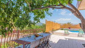 An outdoor dining area with a table and chairs, a pool, and a view of the landscape. - Nice apartment in Danilo with WiFi (Danilo)