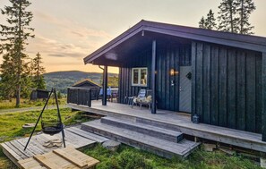 A wooden cabin with a porch, a swing set, and a view of the surrounding landscape. - Gorgeous home in Lillehammer with WiFi (Lillehammer)