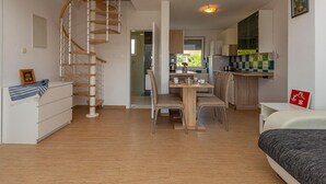A modern apartment with a spiral staircase, a dining area, and a kitchen. - Beautiful home in Rosini (Rosini)