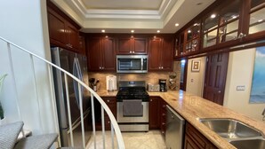 A kitchen with wooden cabinets, stainless steel appliances, a microwave, a stove, and a dishwasher. - Luxurious • Upscale • Open Concept • Elegant • Beautifully Maintained (Huntington Beach)