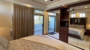A bedroom with a large bed, a ceiling fan, a dresser, and a mirror reflecting the bed. - Luxurious • Upscale • Open Concept • Elegant • Beautifully Maintained (Huntington Beach)