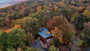 A secluded cabin surrounded by dense forest with a winding road leading to it. - Sunset Mountain Views • 3 King Suites • Hot Tub • Game Room • 8 mi to Dollywood (Sevierville)