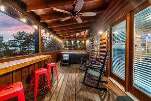Relax in a cozy outdoor space with a hot tub and comfortable seating.