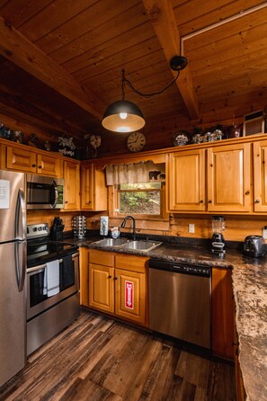 Enjoy cooking in this well-equipped kitchen with a refrigerator, microwave, oven, dishwasher, sink, and countertop appliances.