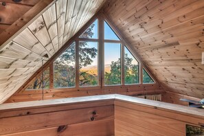 Enjoy a serene forest view from the large windows in this cozy retreat.