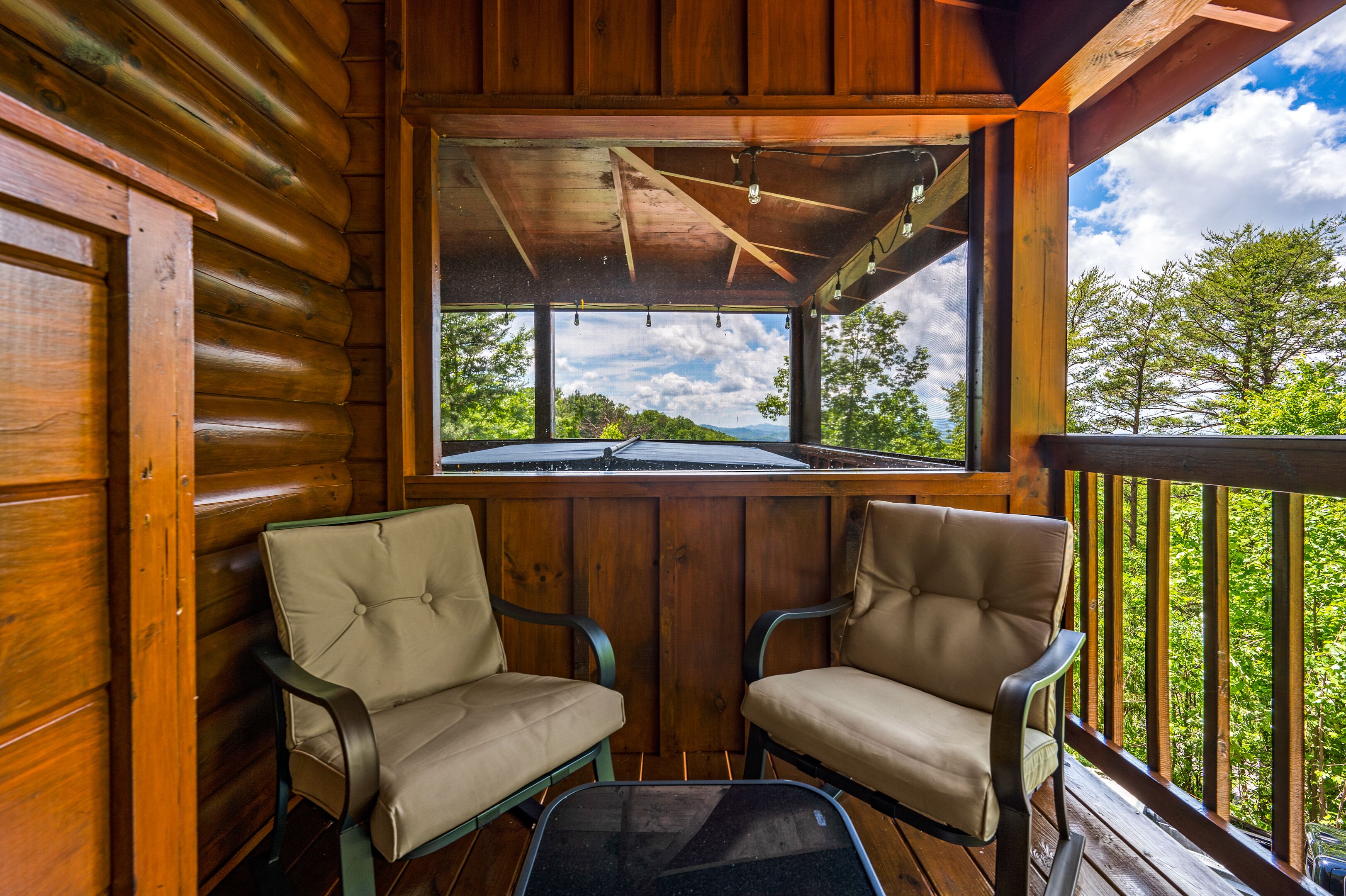 Una cabaña de madera con dos sillones color beige y una mesa de vidrio.