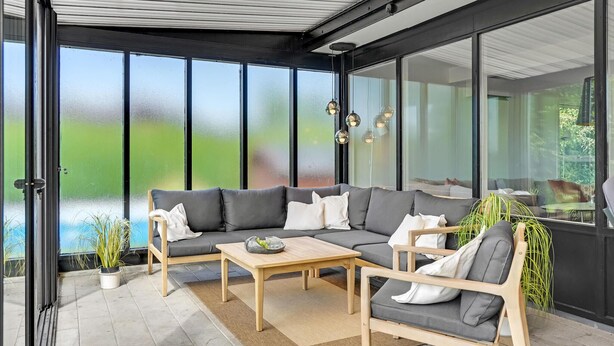 Ein moderner Außenbereich mit Ecksofa, Holztisch und Sitzbank.