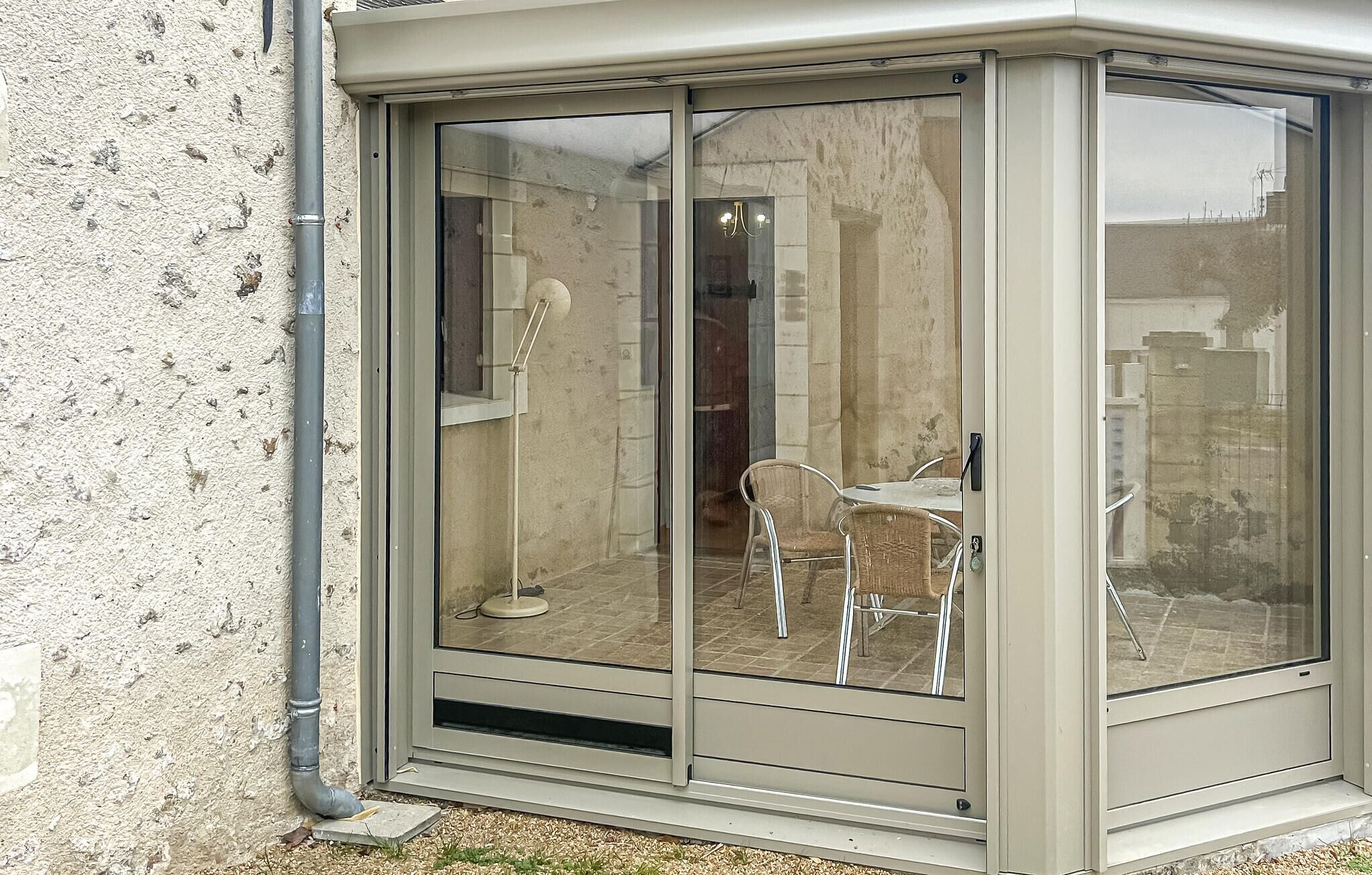 A corner room with a sliding glass door, a small table, and a chair.