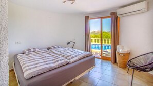 A bedroom with a bed, a desk, and a view of a pool and mountains. - Stunning home in Pedreguer (Pedreguer)