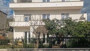 A multi-story residential building with balconies, a gated entrance, and a clear view of the surrounding area. - Gorgeous apartment in Crikvenica with WiFi (Crikvenica)