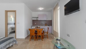 A compact living space with a kitchenette, a dining area, and a small TV mounted on the wall. - Gorgeous apartment in Crikvenica with WiFi (Crikvenica)