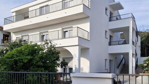 Un edificio moderno de varios pisos con balcones y una escalera.