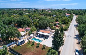 An aerial view of a residential area with houses, a swimming pool, and a road. - Luxurious home in Peroj (Peroj)