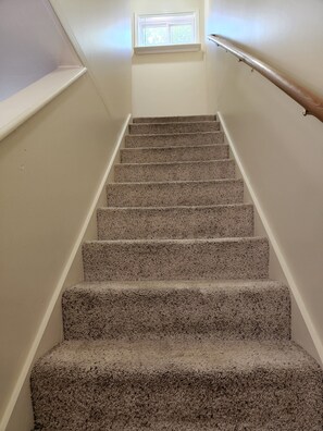 Stairs lead upwards to a window at the top, offering a view.