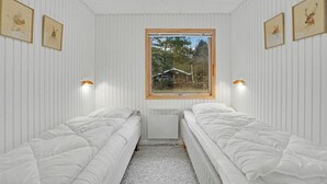 A room with two single beds, a window with a view of a house, and wall-mounted lamps. - Stunning home in Fårvang with WiFi (Fårvang)