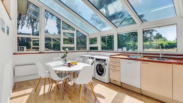 A bright kitchen with a dining area, large windows, and a washing machine. - Stunning home in Fårvang with WiFi (Fårvang)