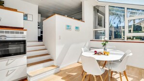 A modern kitchen with white cabinetry, a built-in oven, and a dining area with a white table and chairs. - Stunning home in Fårvang with WiFi (Fårvang)
