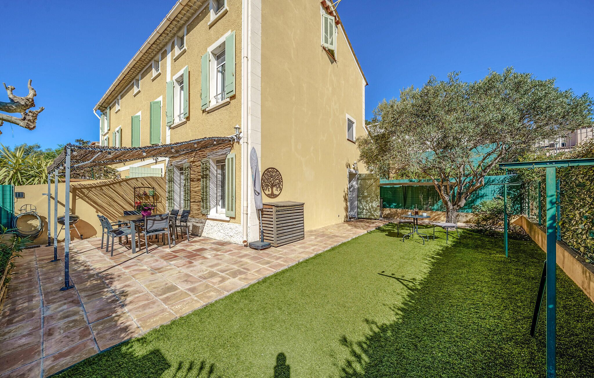 Una casa de dos pisos con un patio y un pequeño jardín.