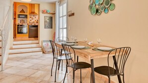 A dining area with a wooden table, four chairs, and a decorative wall piece. - Amazing home in Sanary-sur-Mer with WiFi (Sanary-sur-Mer)