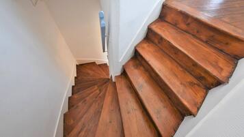 Eine Holztreppe mit weißen Wänden und einem blauen Geländer.