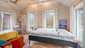 A bedroom with a bed, a chair, a lamp, and a window with curtains. - Amazing home in Skjern with kitchen (Skjern)