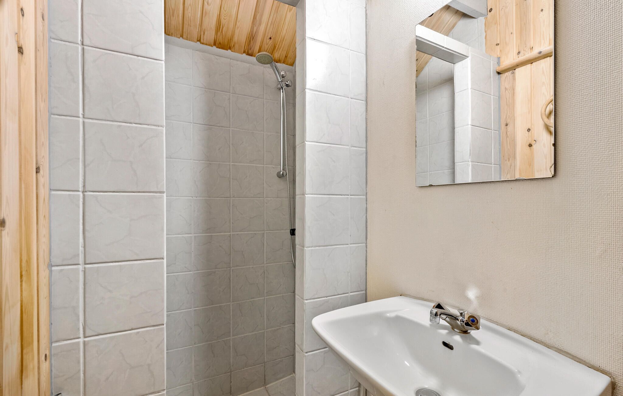 A bathroom with a shower, a sink, and a mirror.