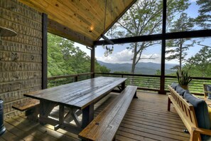 A wooden deck with a picnic table and benches, overlooking a mountainous landscape. - Gem of Blue Ridge | Pool + Views + Hot Tub (Blue Ridge)