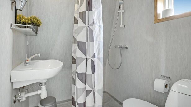 A bathroom with a white sink, a shower, and a toilet. - 1 bedroom gorgeous home in Kolding (Kolding)