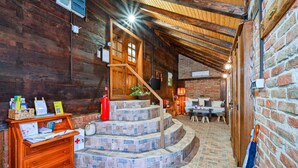Um interior rústico com escada de madeira, lareira e área de jantar.