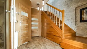 Eine Holztreppe mit Glastrennwand, die zu einer oberen Etage führt.
