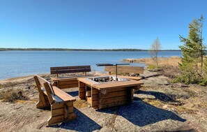A wooden outdoor seating area with benches and a table by a lake. - Stunning home in Säffle with WiFi (Säffle)