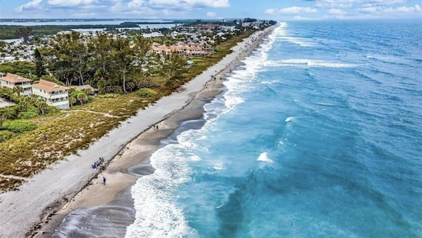 Vista costera con playa, océano y zona residencial.