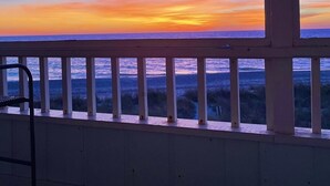 Un balcón con vista al océano al atardecer.