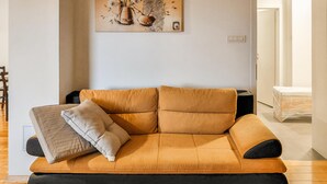 A modern living room with a sofa, a coffee table, and a painting on the wall. - 2 bedroom awesome apartment in Crikvenica (Crikvenica)