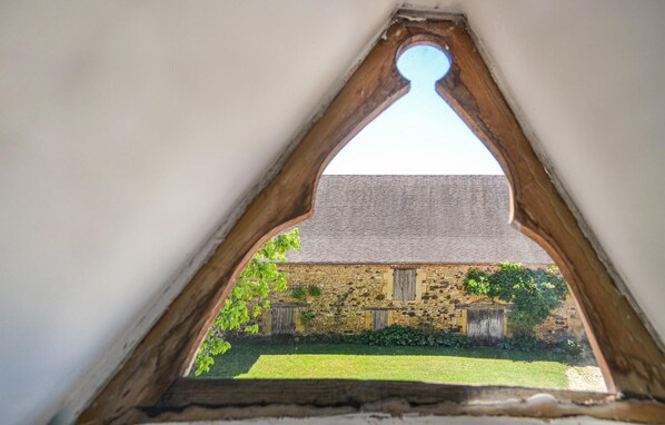 A triangular window with a stone building visible through it. - Amazing home in Montferrand-du-Perigor (Montferrand-du-Perigor)