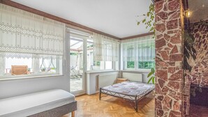 Ein Schlafzimmer mit einem Bett, einer Bank und Blick ins Freie.