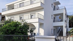 Un immeuble moderne à plusieurs étages, doté de balcons et d’un escalier.