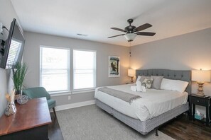 Relax in this serene bedroom with a large bed, bedside tables, and a flat-screen TV.