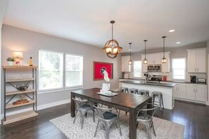 Enjoy meals in the kitchen with stainless steel appliances and a central island, adjacent to a dining area with a wooden table and four chairs.
