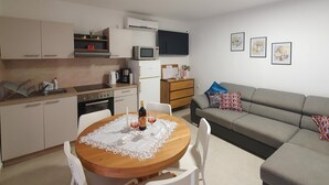 A compact living space with a kitchenette, dining area, and a sofa.