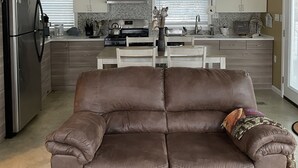 A modern kitchen with a central island, stainless steel appliances, and a chandelier. - Shore Cliff Cottage  (Ashtabula)