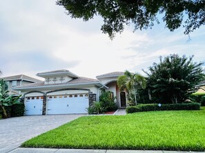 Two-story house with a garage, lawn, and landscaping.